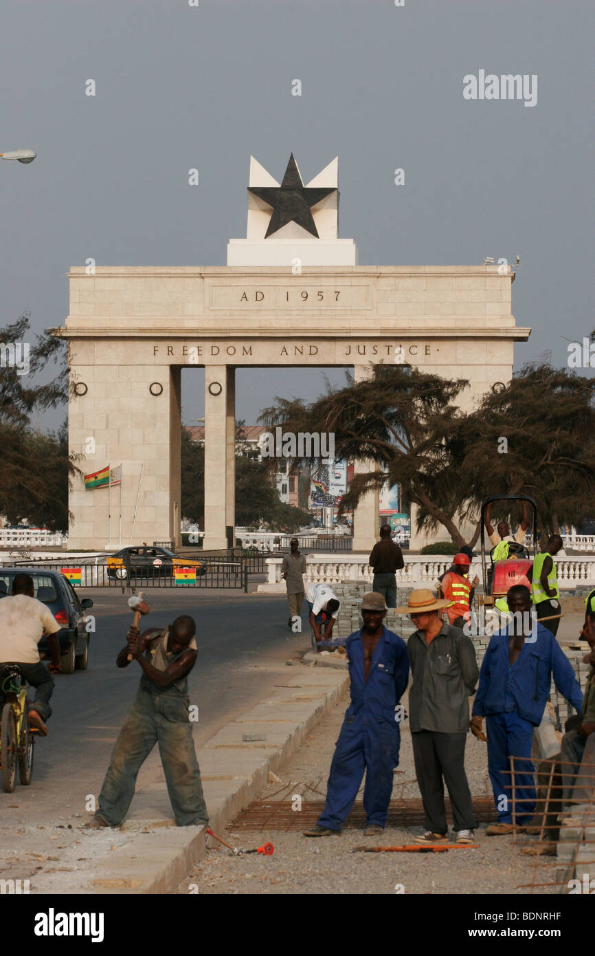 Road workers led by Chinese foreman repair the pavement near Independence Square and the Black Star monument. Accra. Ghana. Stock Photo