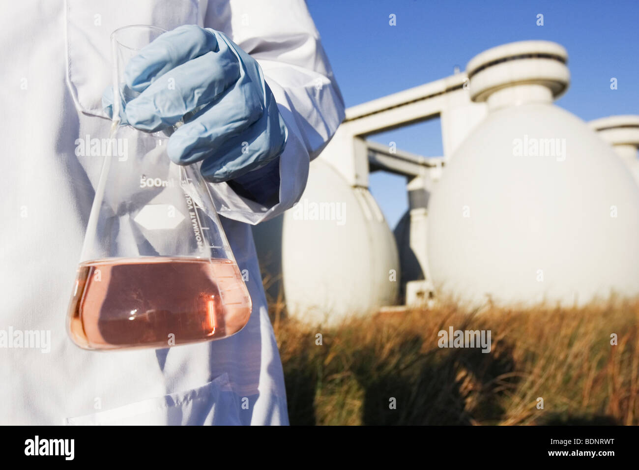 Scientist holding a flask of water sample Stock Photo