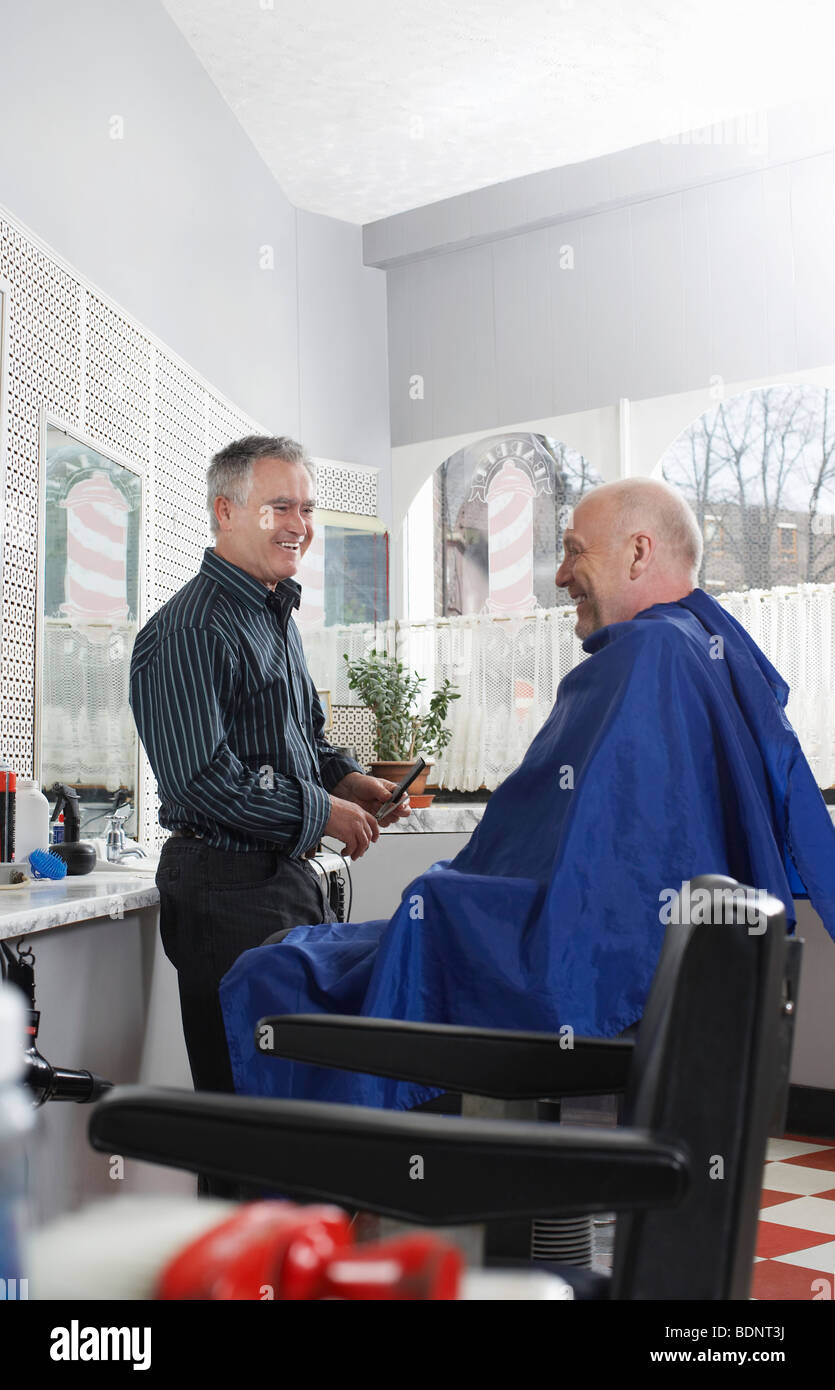 Barber and man in barbers shop, smiling Stock Photo