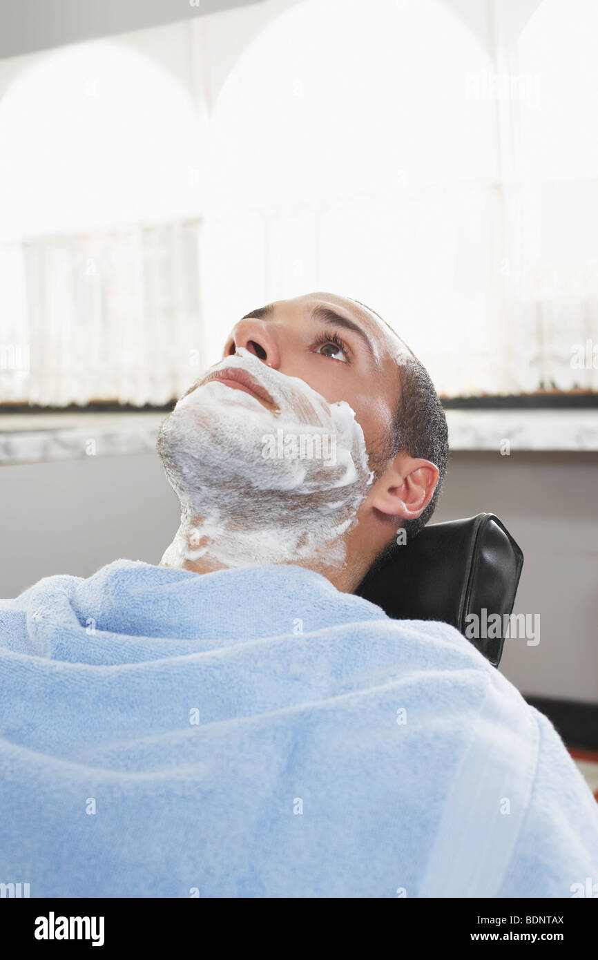 Man with shaving foam on face at barbers Stock Photo Alamy