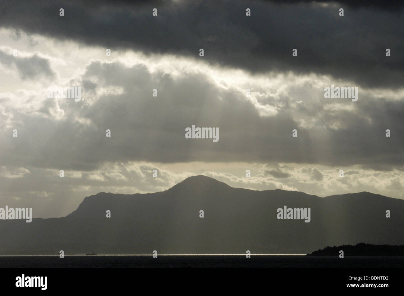 Sun breaks over Bjørnafjorden with the Folgefonn mountains on the horizon in Norway North Europe. Stock Photo