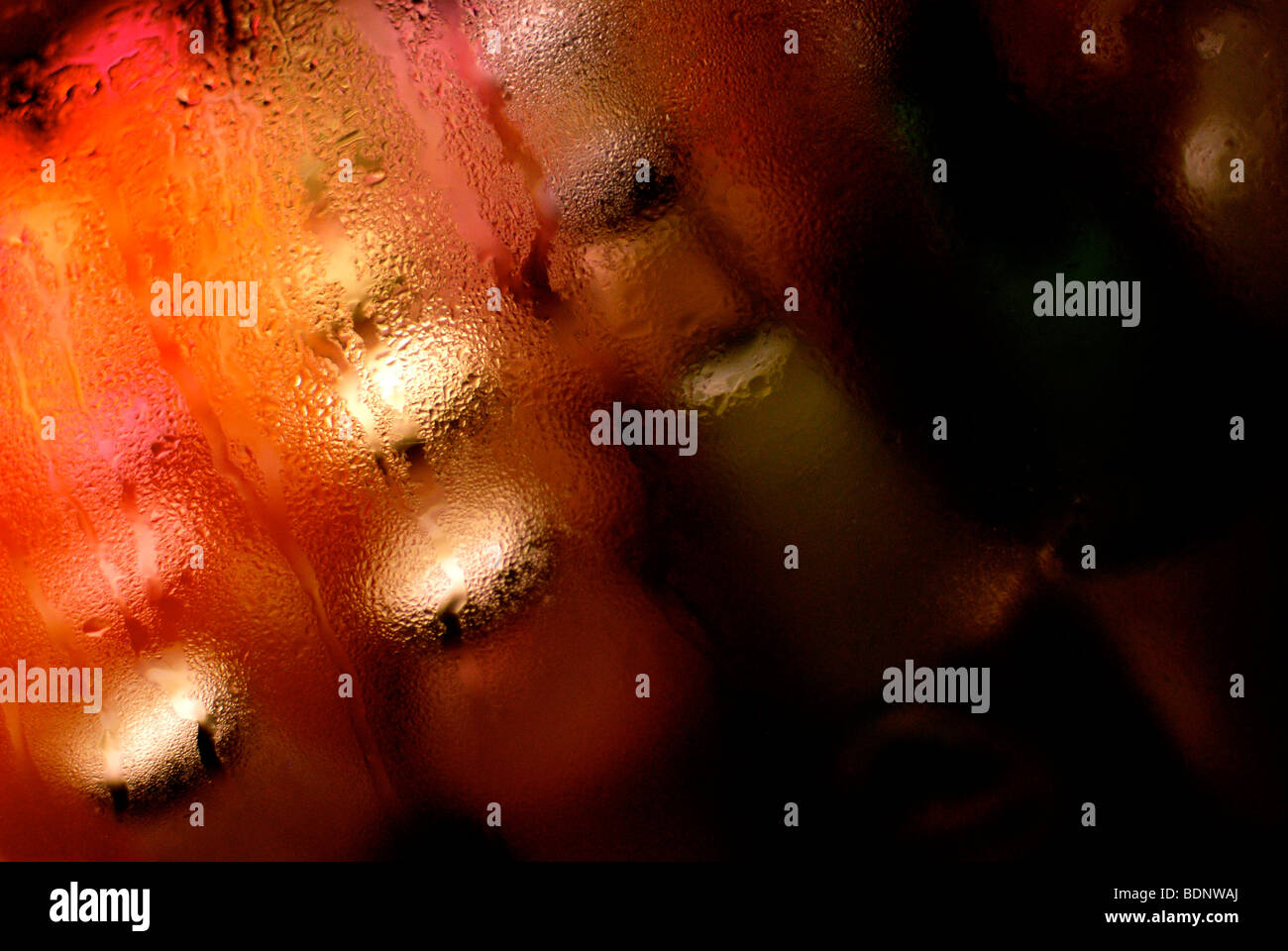 Glass bottles behind a screen with condensation during a heat wave in summer. Stock Photo
