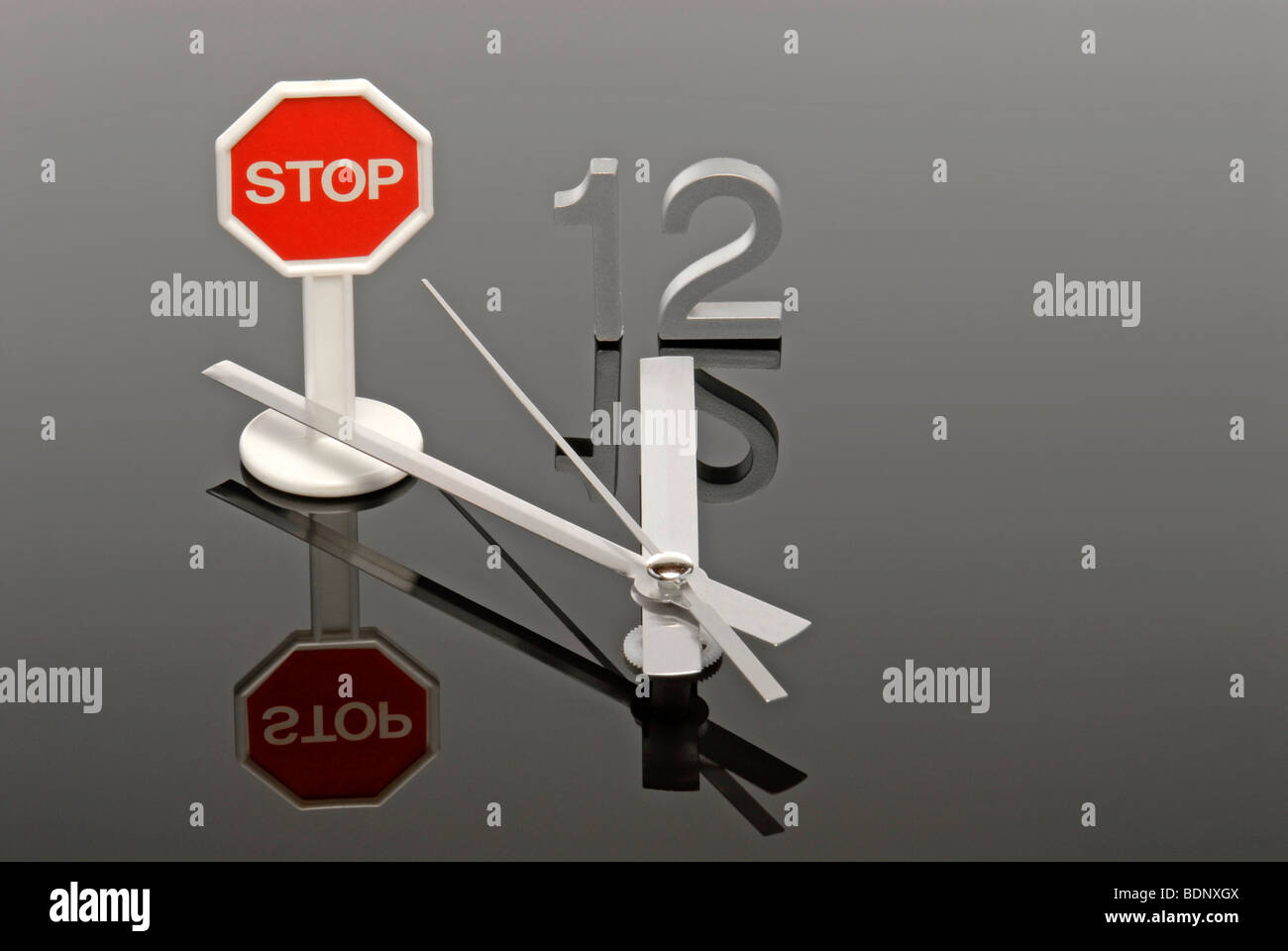 Clock showing five to twelve, stop sign stopping the hand, symbolic picture for stopping a crisis Stock Photo