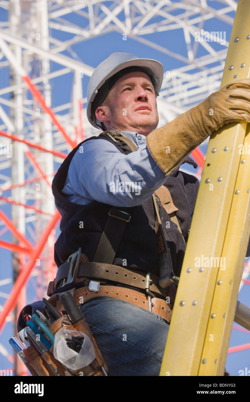 Cable lineman climbing a ladder to repair transmission line Stock Photo Alamy