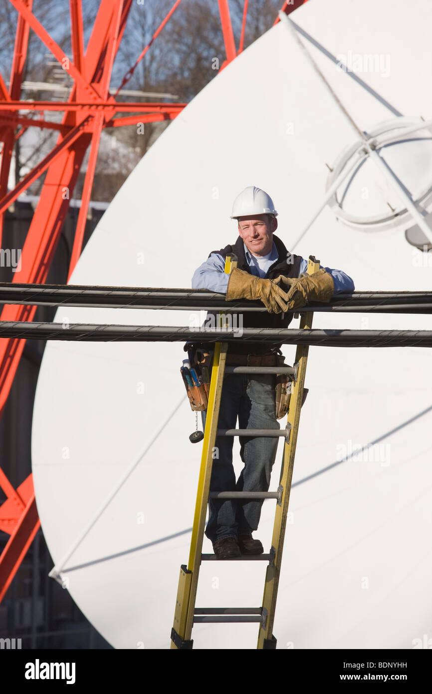 Cable lineman standing on a ladder to repair transmission line Stock Photo Alamy