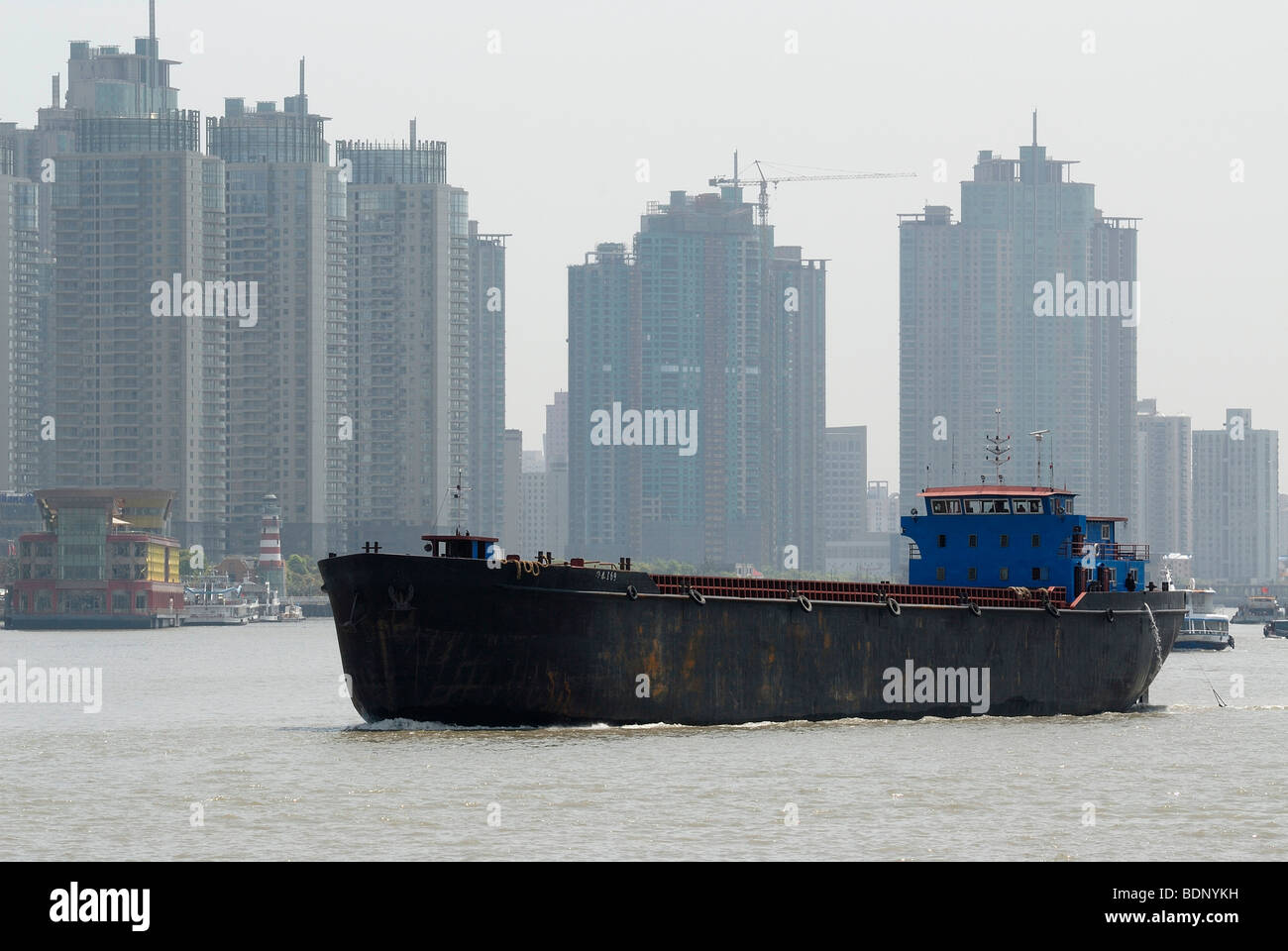 Freighter, barge transportation on the Huangpu River in front of Chinese high-rise buildings, Shanghai, China, Asia Stock Photo