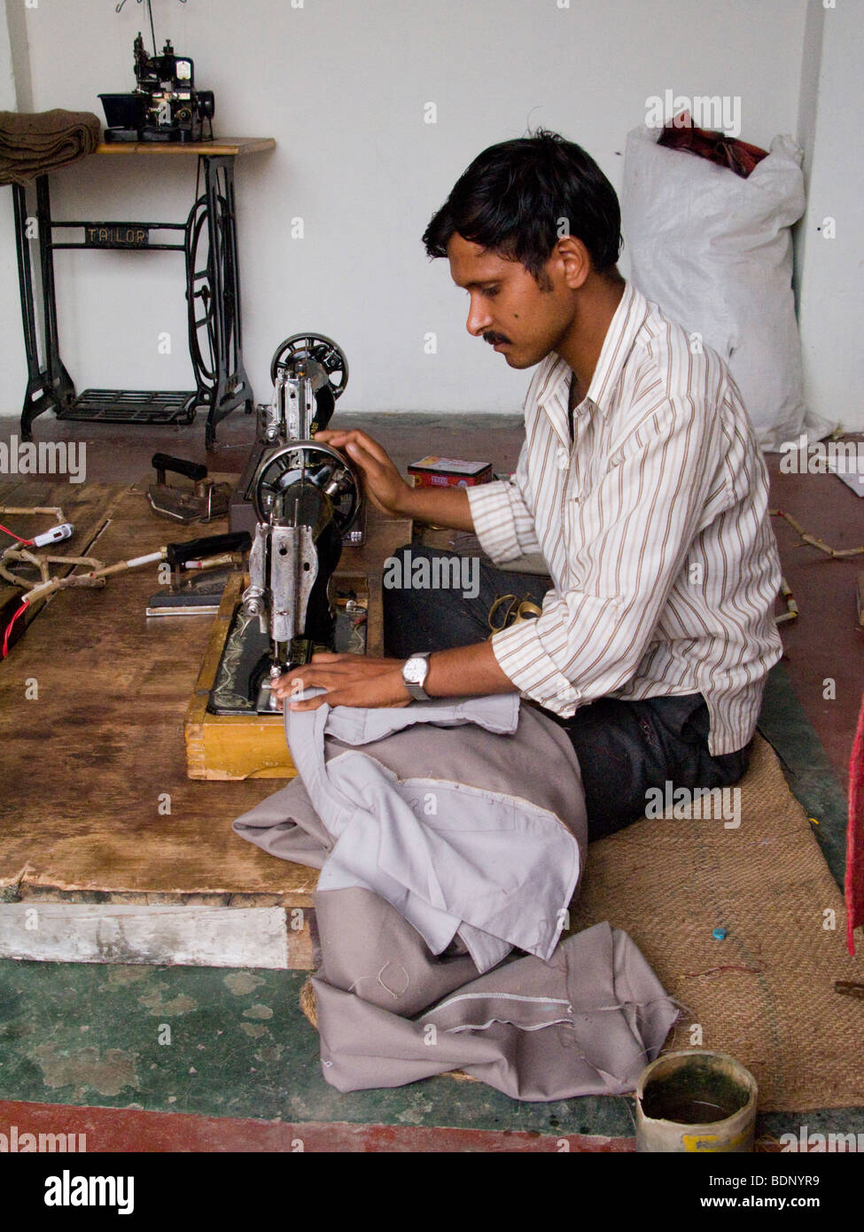 Tailor working on a sewing machine in a tailors shop in Rewalsar. Himachal Pradesh. India Stock