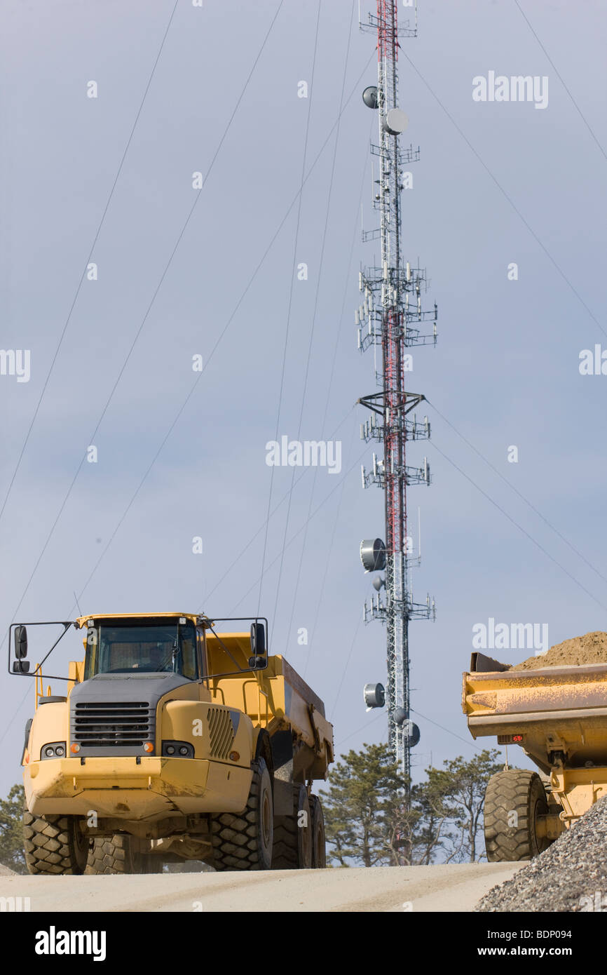 Earth mover at a construction site with a cellular tower in the background Stock Photo