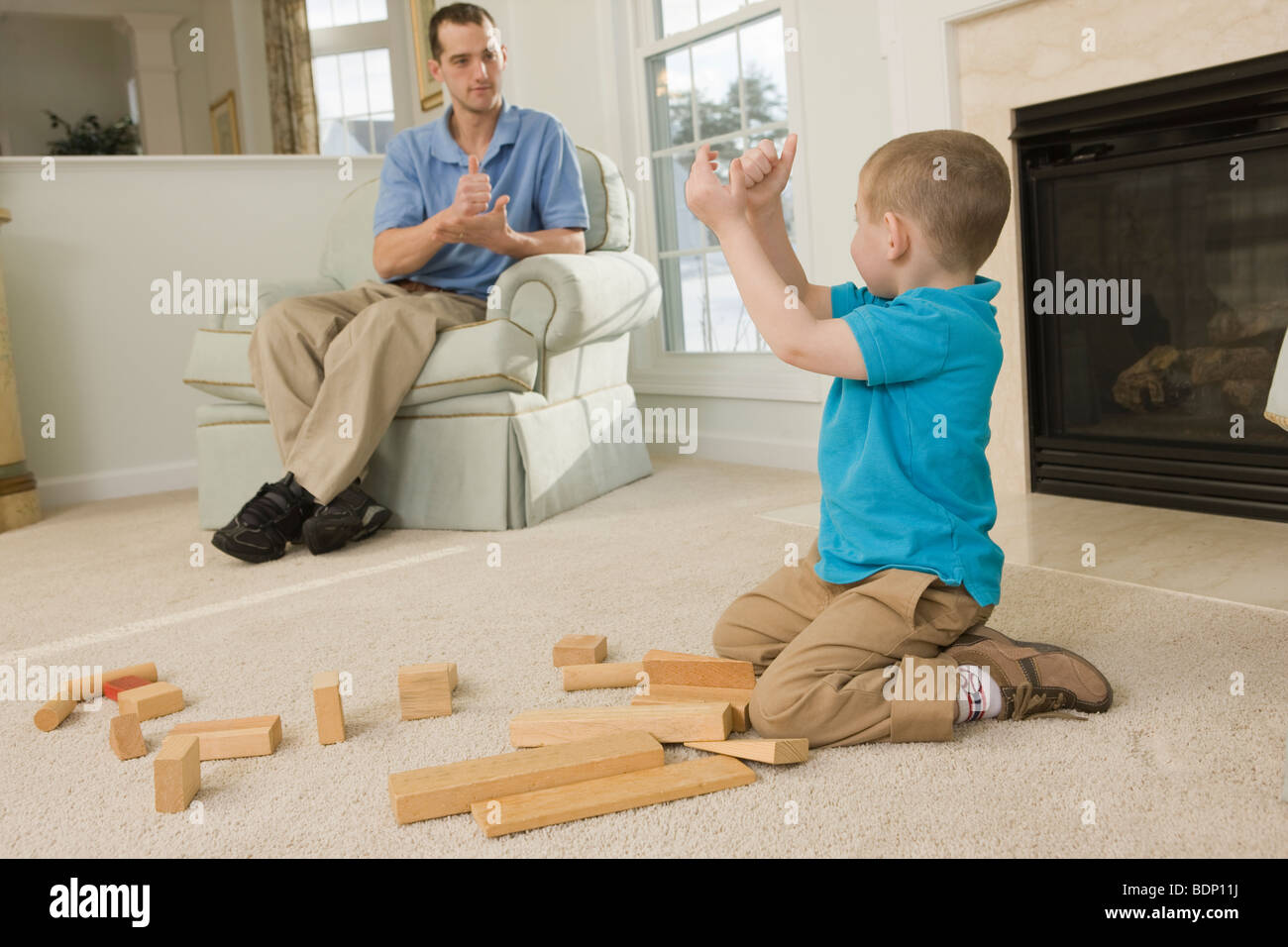 Man signing the word 'Help' in American Sign Language while communicating with his son Stock Photo