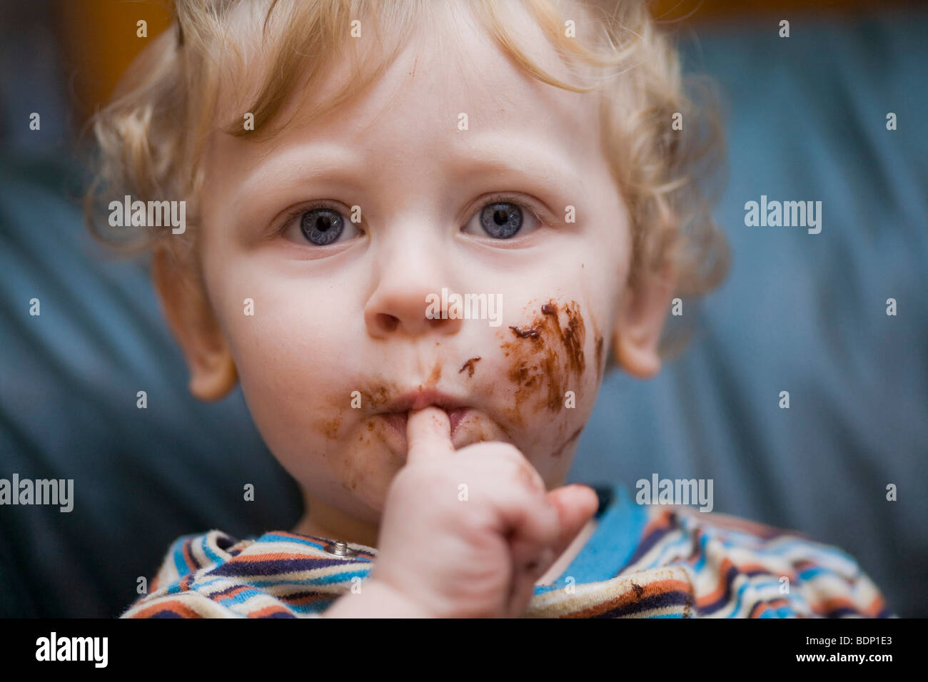 One-year boy with chocolate covered fingers Stock Photo