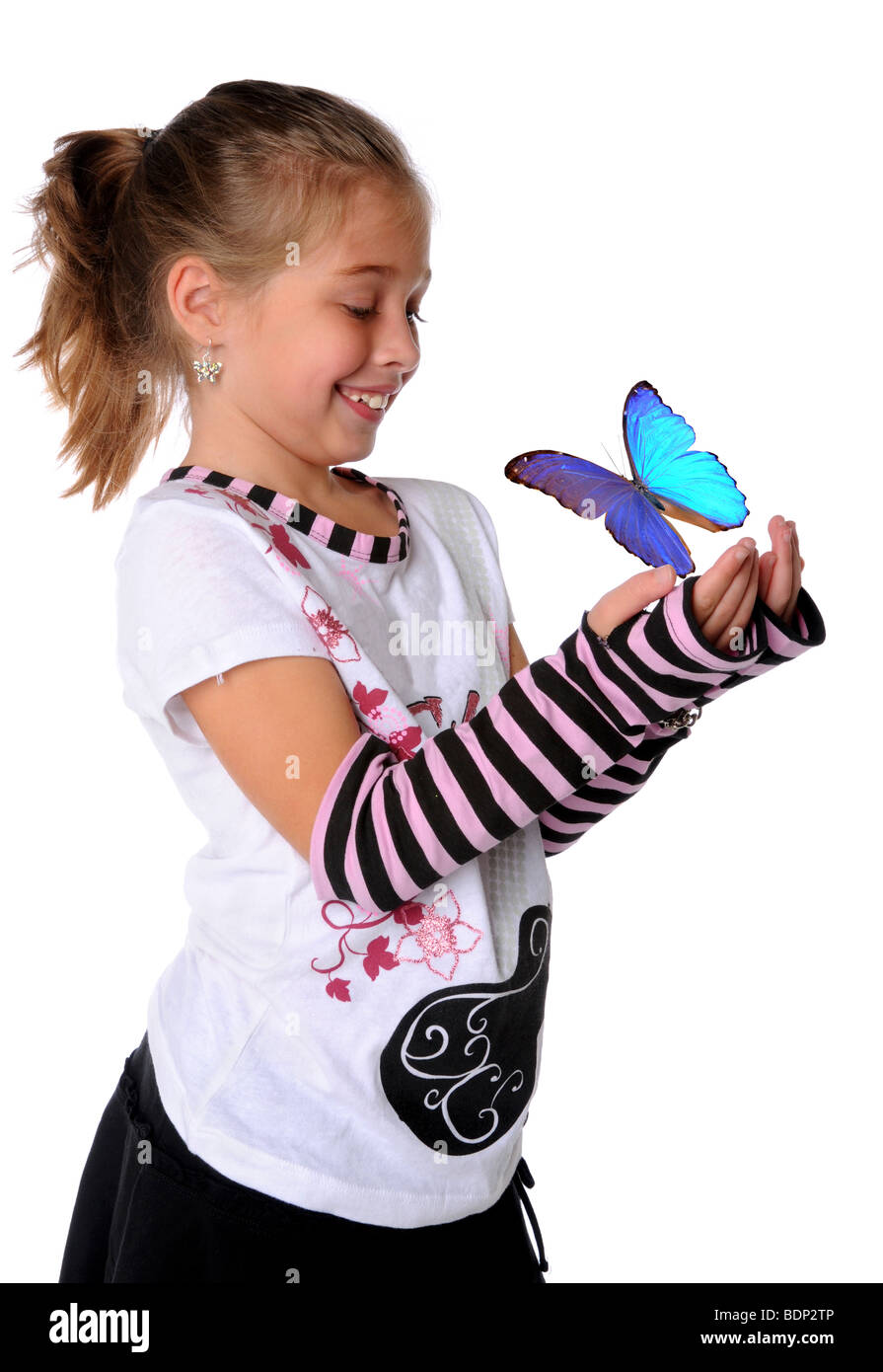 Young girl with butterfly flying off hands Stock Photo