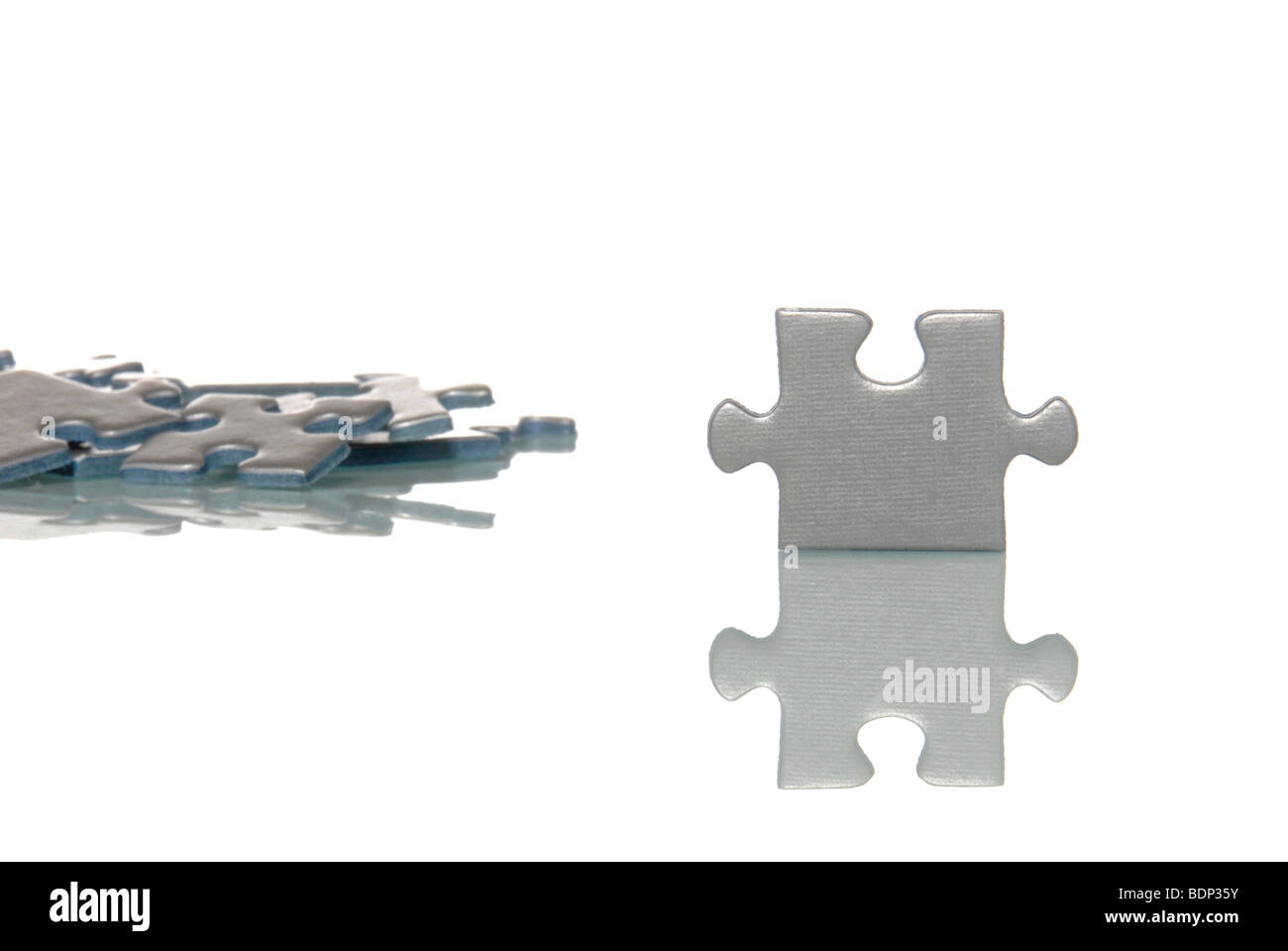 A standing puzzle piece with lying pieces, symbolic picture for the