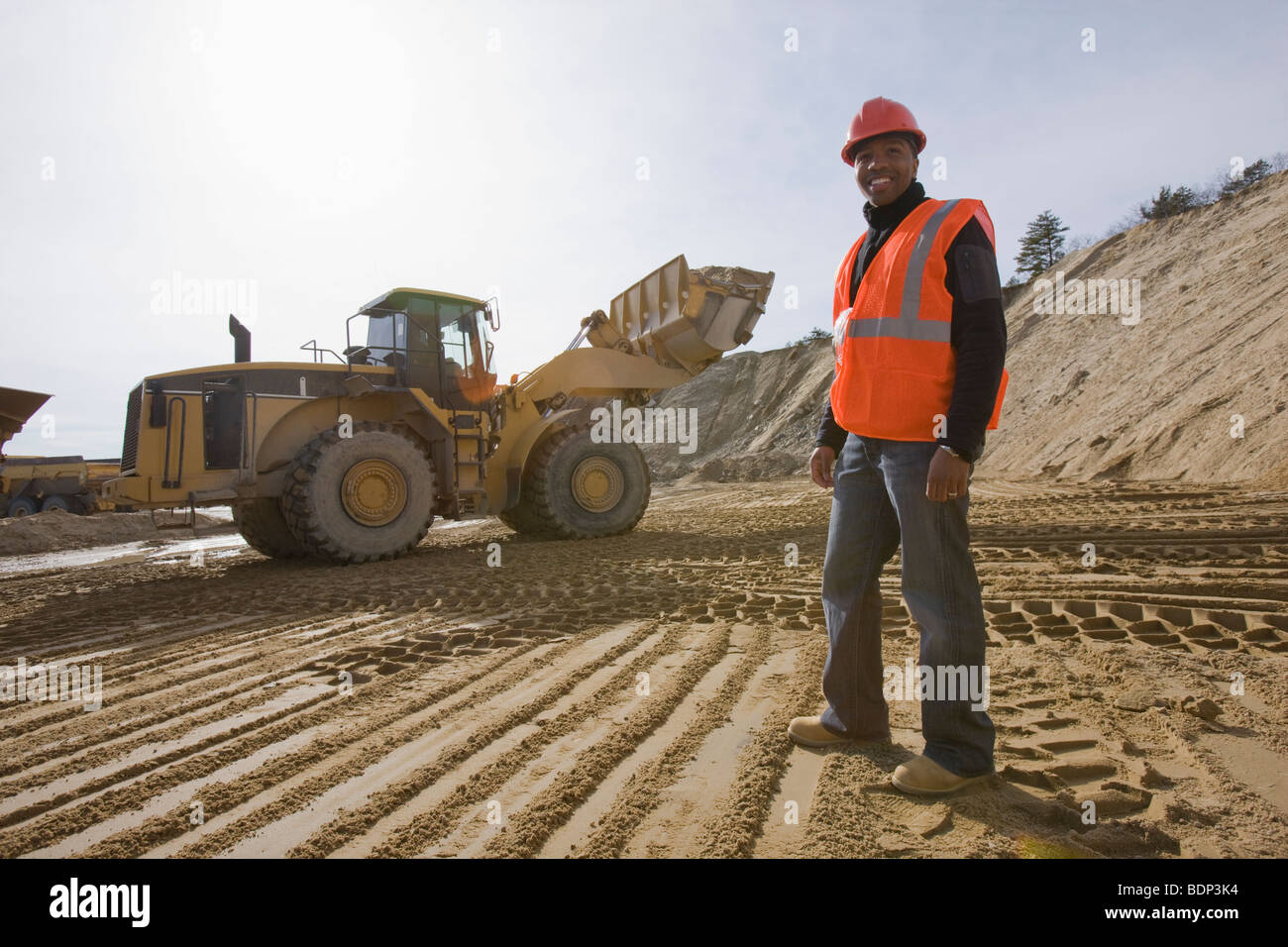 Engineer at a construction site with a front-end loader in the background Stock Photo