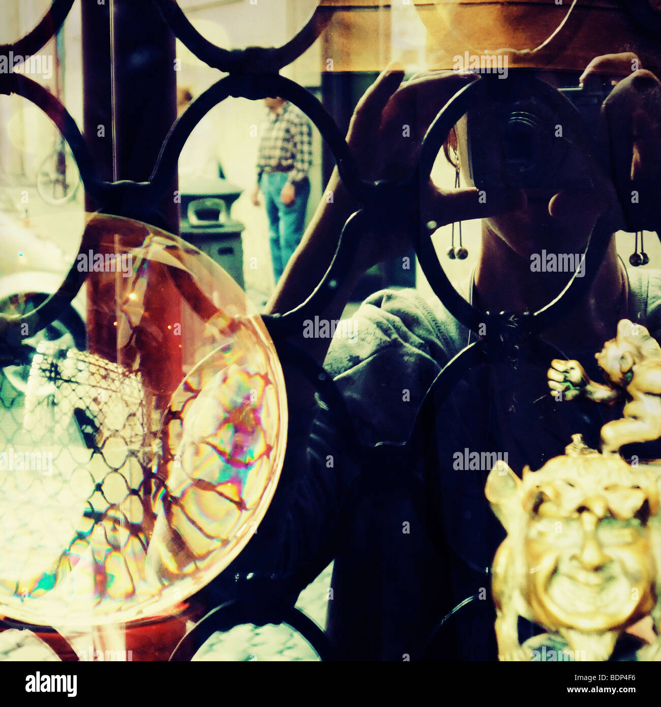 double reflection of a girl taking a picture through an ornate doorway
