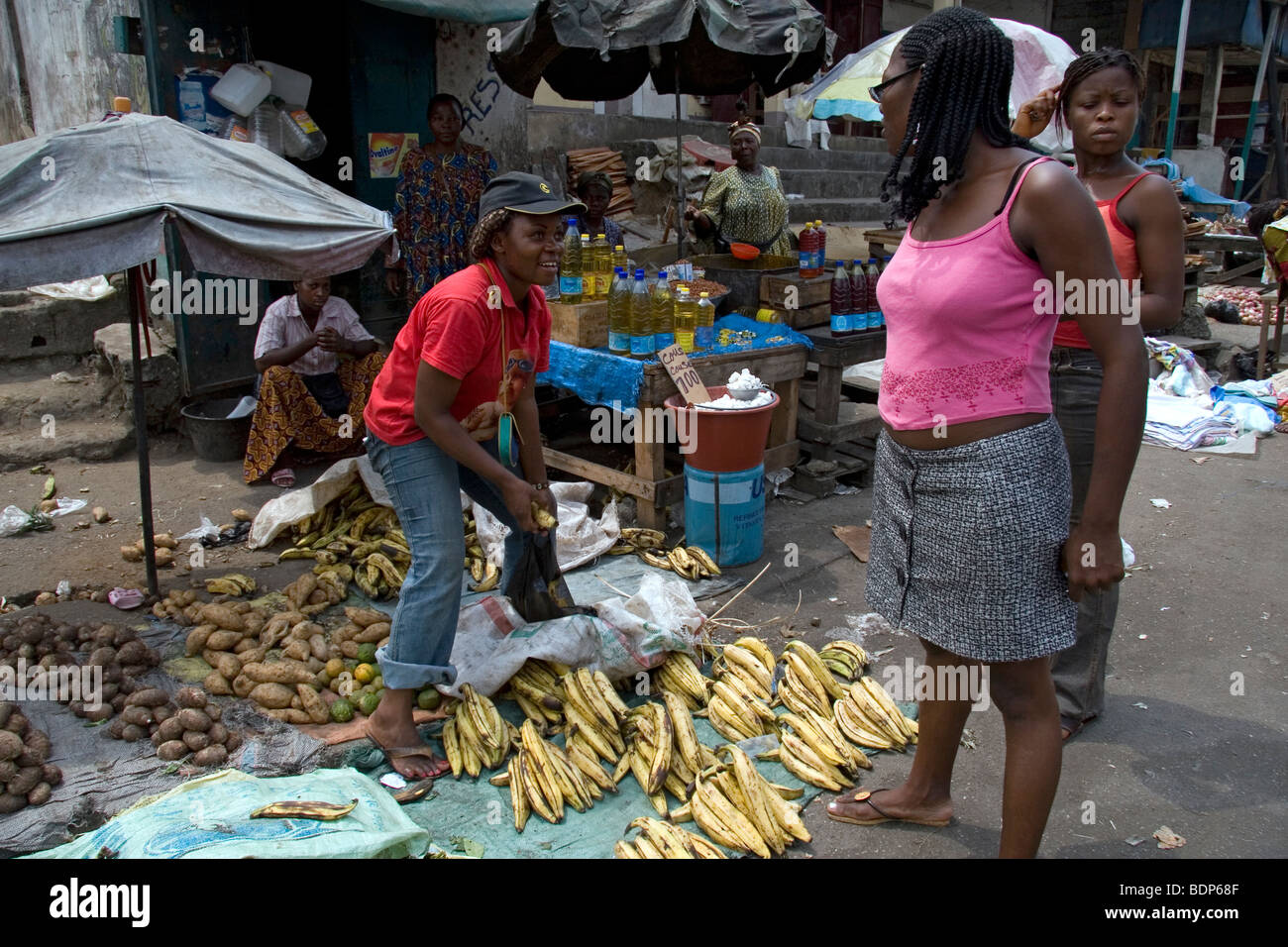 Street market in poor neighborhood of Grand Moulin Douala Cameroon West Africa with stalls selling plantain yam cooking oil Stock Photo