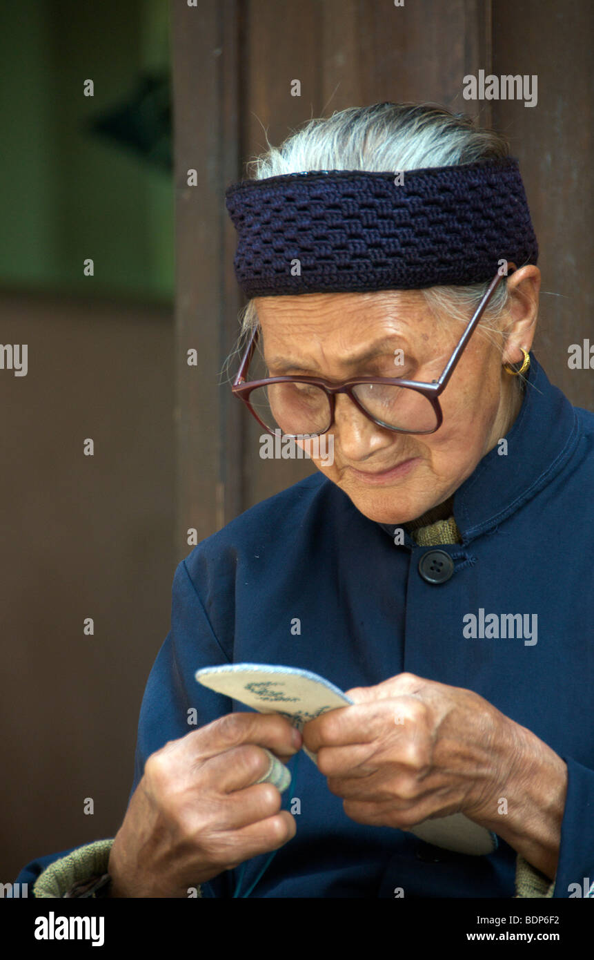 Portrait elderly woman making embroidery Old Furong Town Hunan Province China Stock Photo