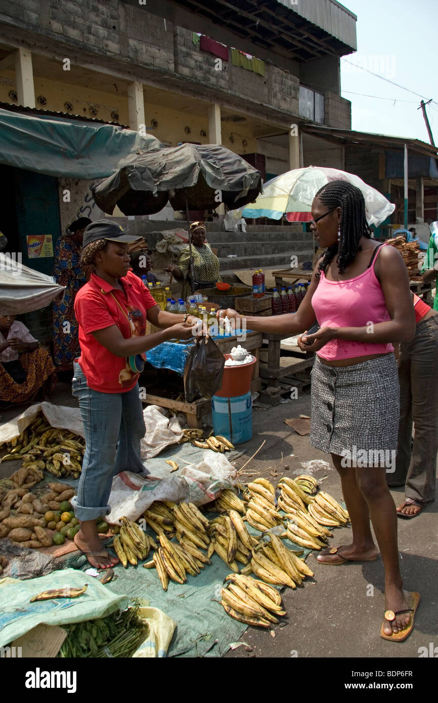 Street market in poor neighborhood of Grand Moulin Douala Cameroon West Africa with stalls selling plantain yam cooking oil Stock Photo