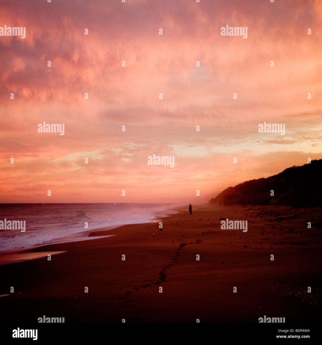 The Australian coast at sunset with a figure in the distance Stock Photo