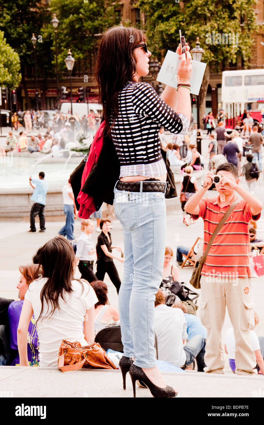 Woman taking photograph in Trafalgar Square, London, UK Stock Photo
