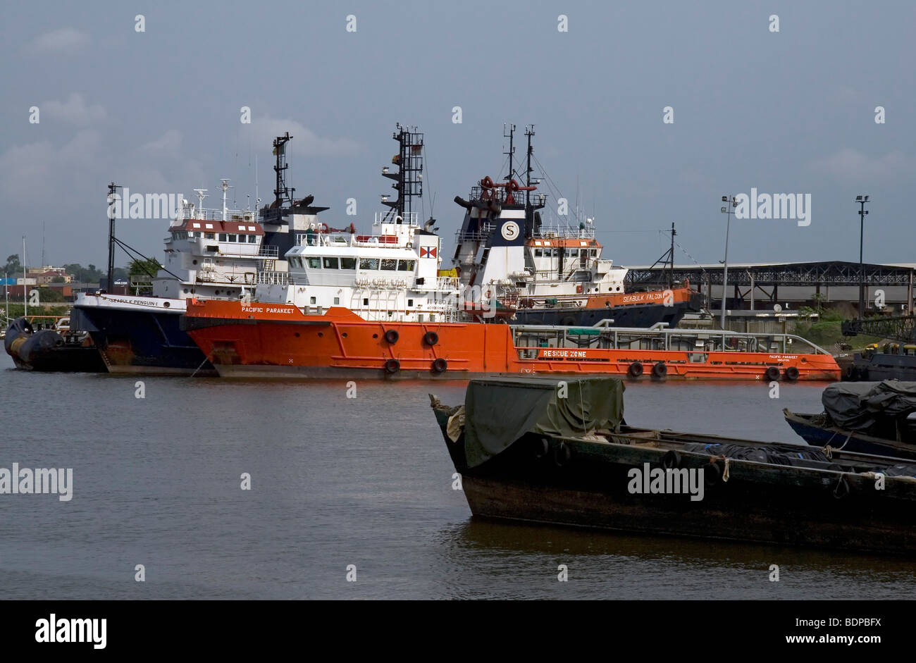 Dock scene at Douala Cameroon West Africa with oil industry supply and tug vessels including M/V Pacific Parakeet Stock Photo
