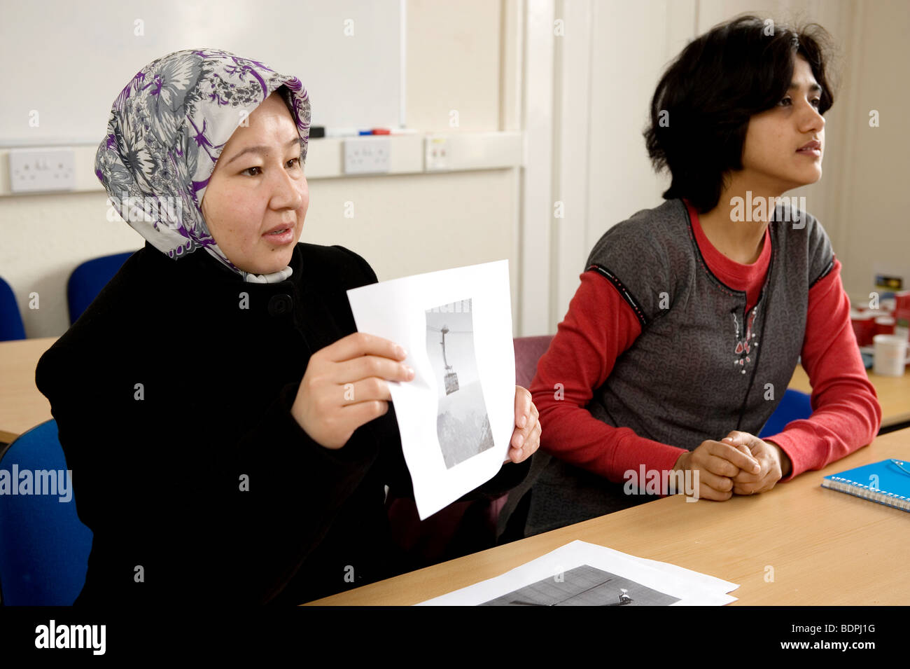 Foreign nationals learn English in a classroom using pictures. Stock Photo