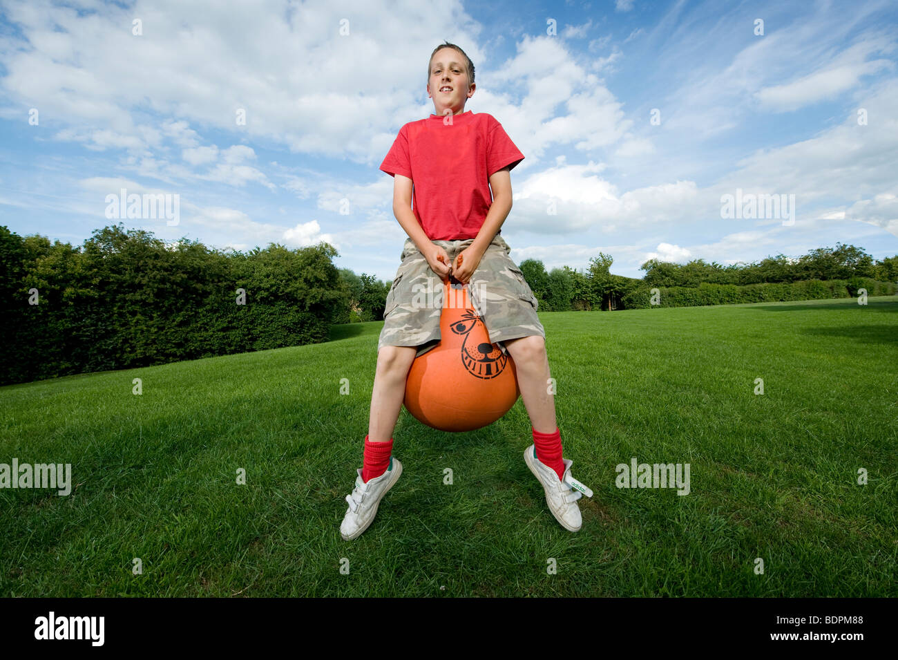Teenage boy bouncing on a space hopper during summer in England Stock Photo Alamy