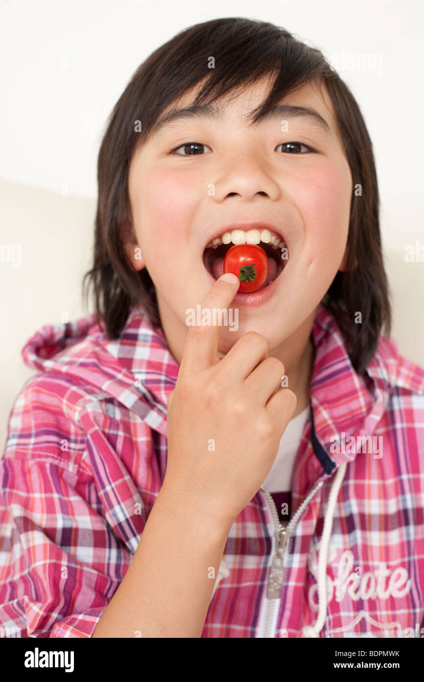 Boy eating tomato Stock Photo - Alamy