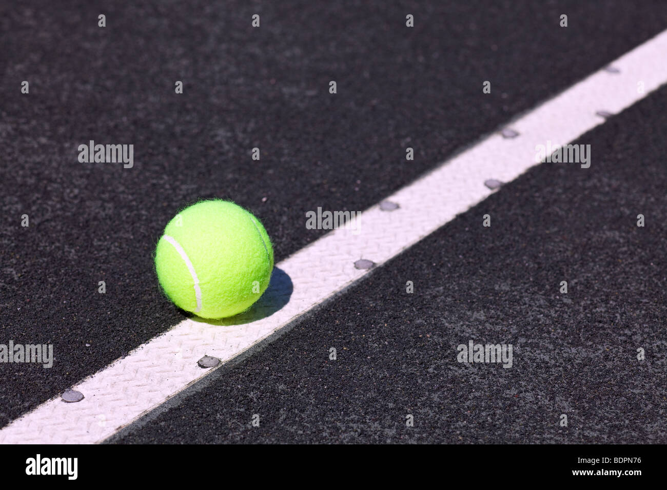tennis ball on serve line of court Stock Photo