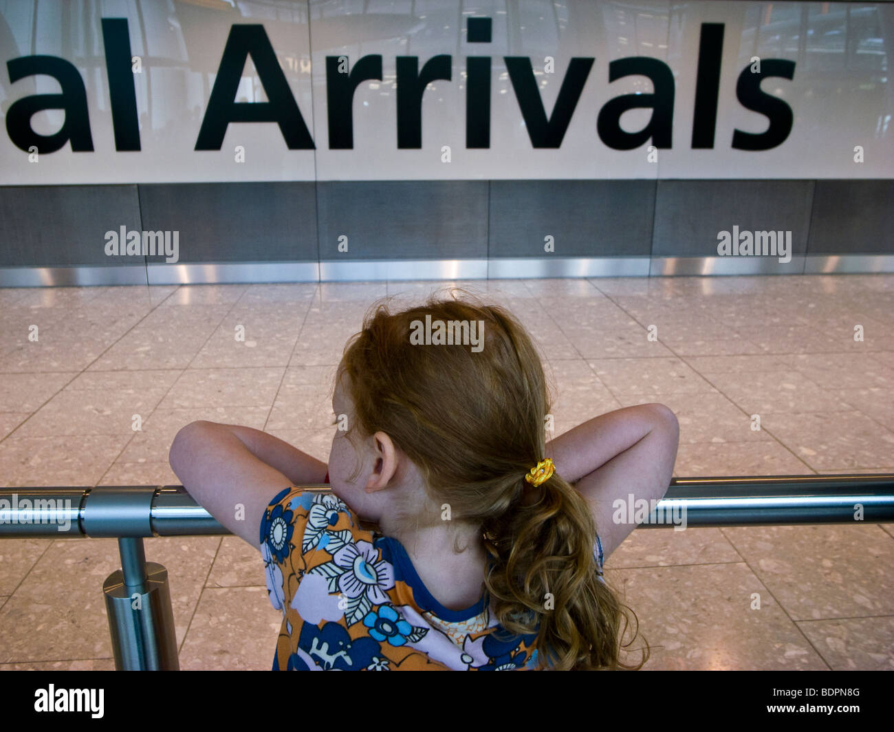 Girl waiting at an airport arrivals hall Stock Photo