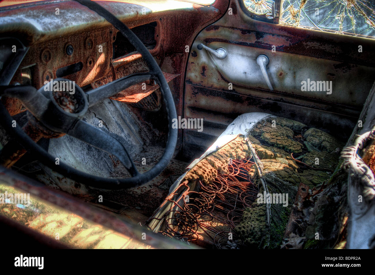 A wrecked old car with driving wheel and broken seat Stock Photo Alamy