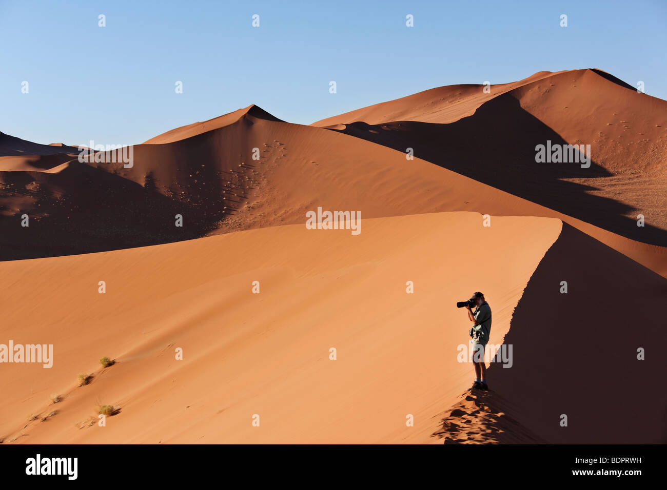 Dune walking in the Namib Desert at Sossusvlei in Namibia Stock Photo ...
