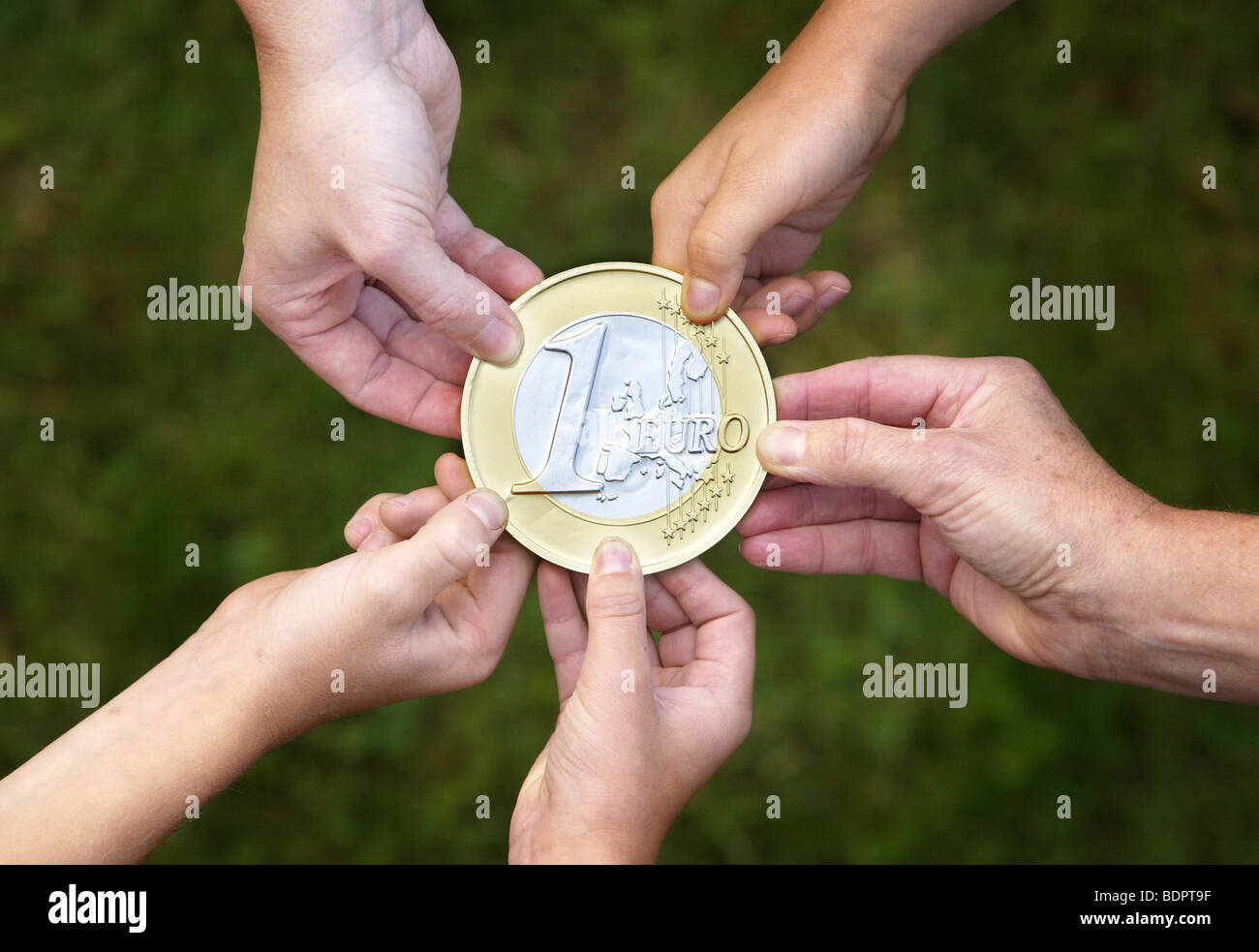 People holding a Euro-Coin Stock Photo