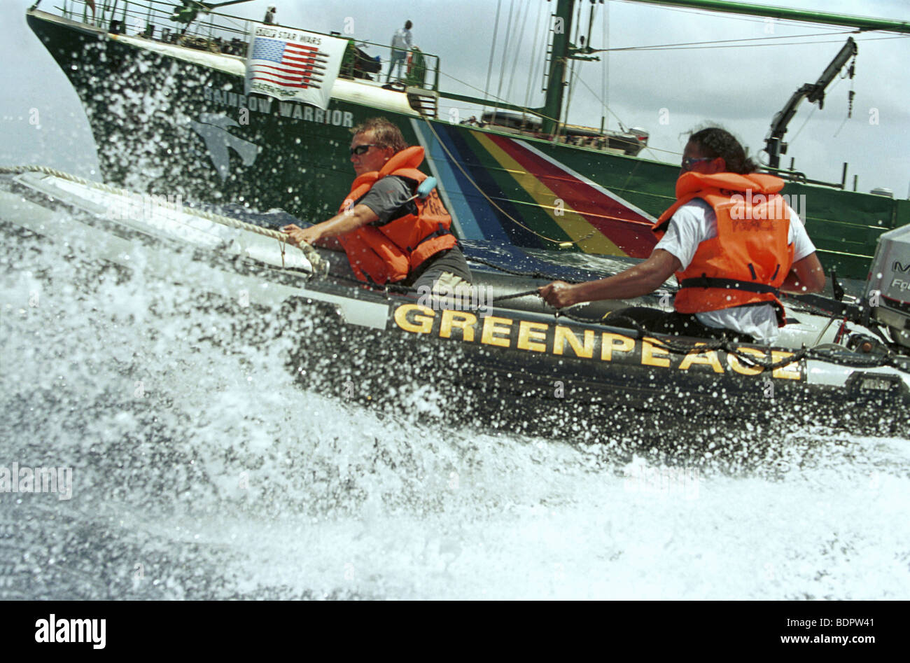 Close view of inflatable on waves in foreground, Rainbow Warrior in back. Stock Photo