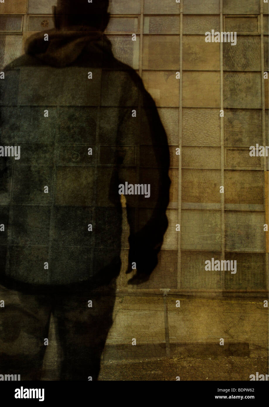 The silhouette of a man walking towards a high rise building Stock Photo