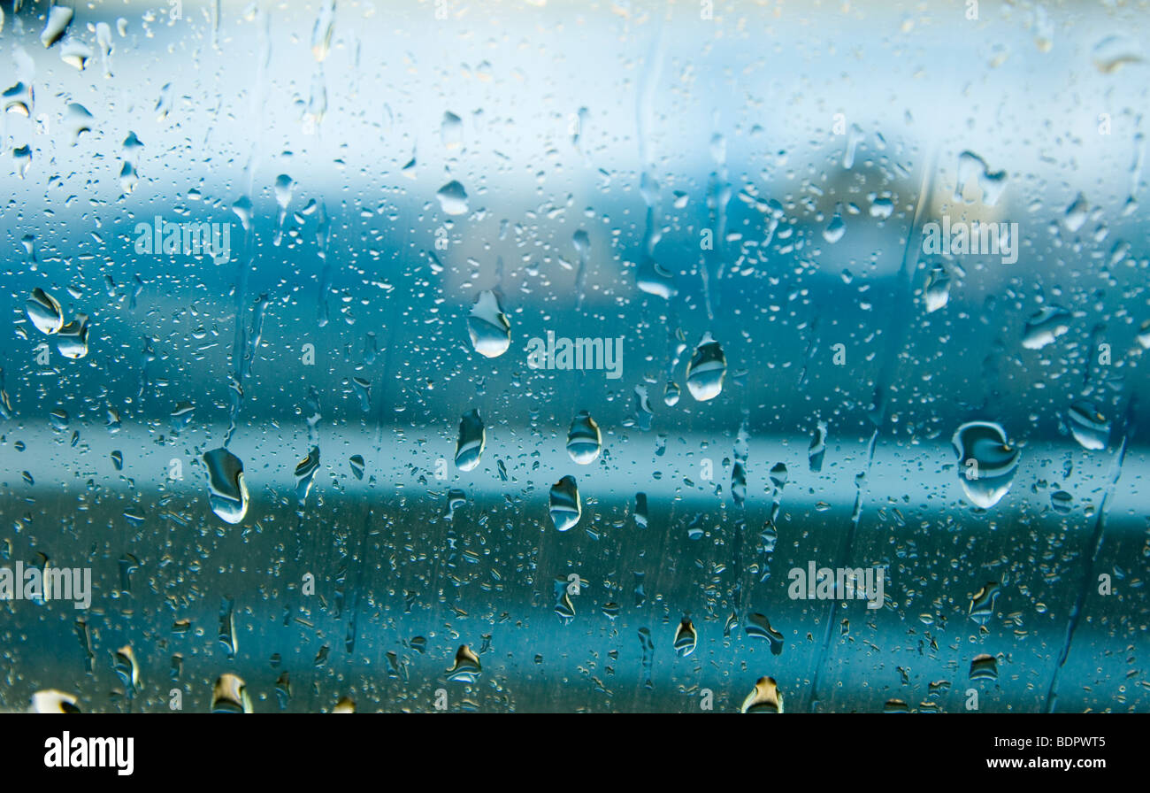 rain drops rolling down the outside of glass on a wet and windy day Stock Photo