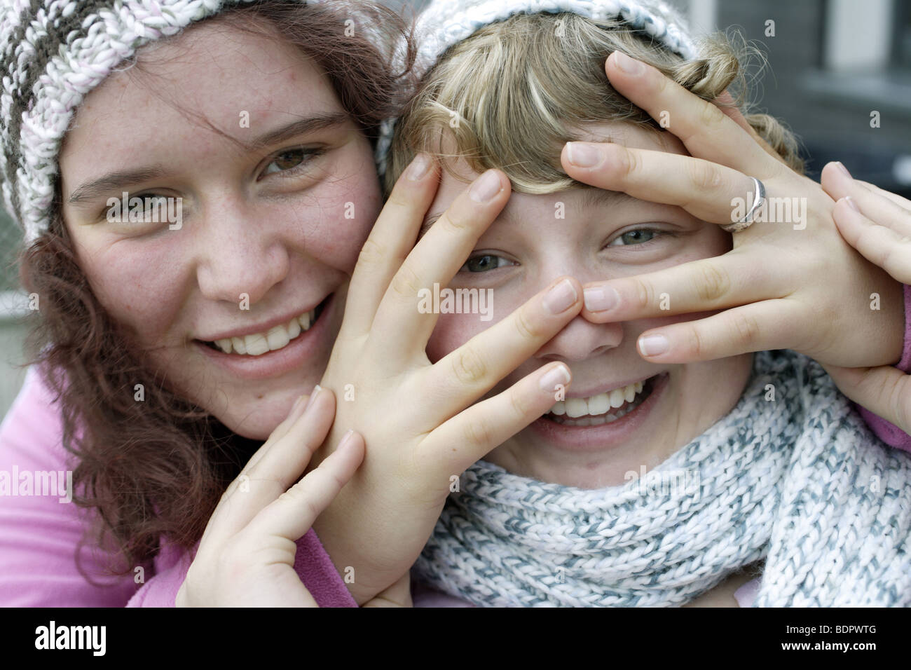 Zwei M aedchen , 14 Jahre alt, mit Muetze und Schal Stock Photo