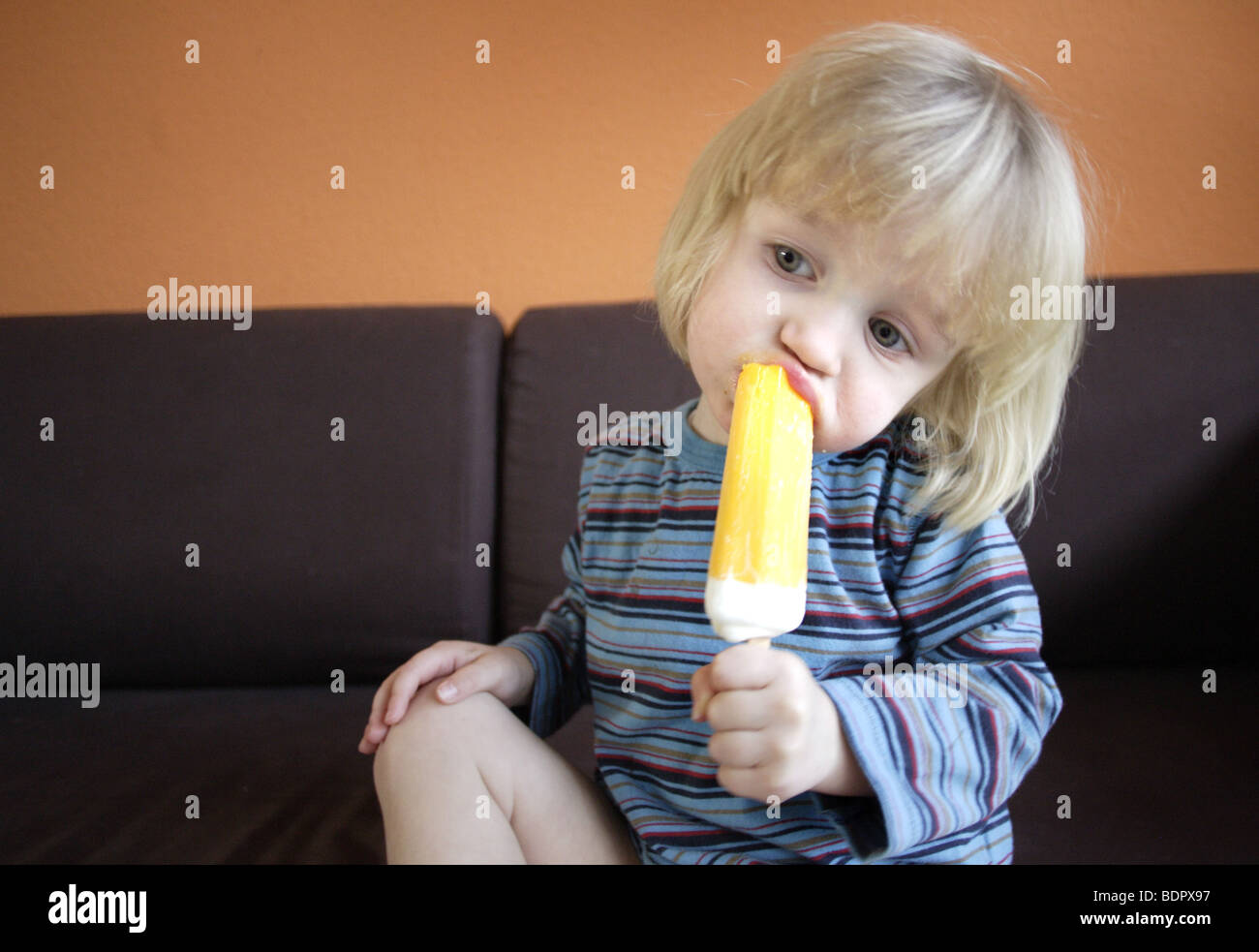 Kind und Eis am Stil auf dem Sofa Stock Photo