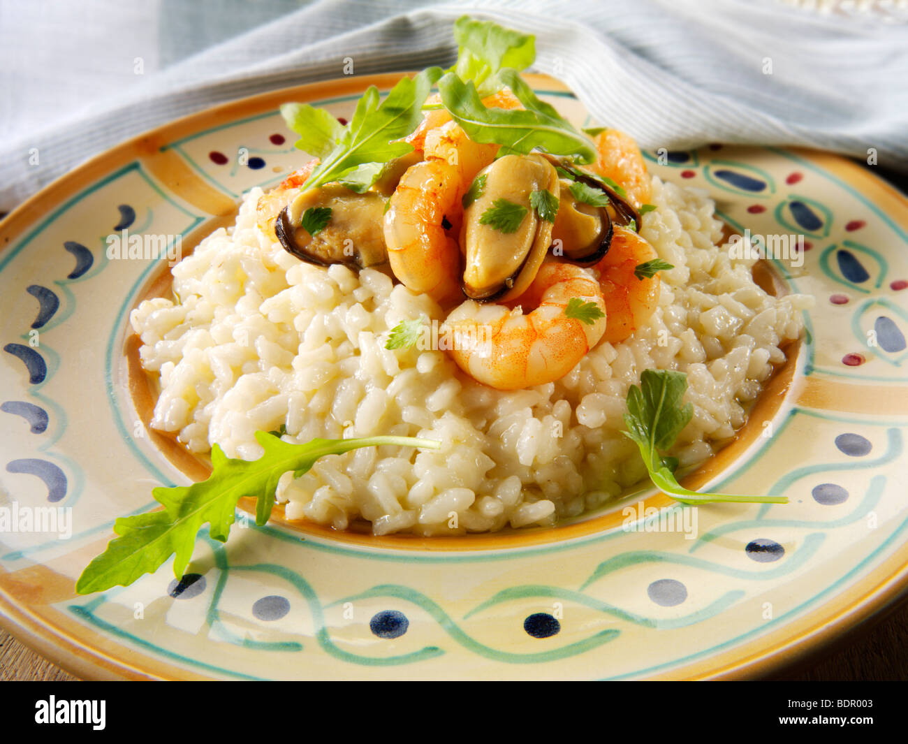 Fresh cooked prawns and mussels risotto, served plated on a table setting. Serving suggestion Stock Photo