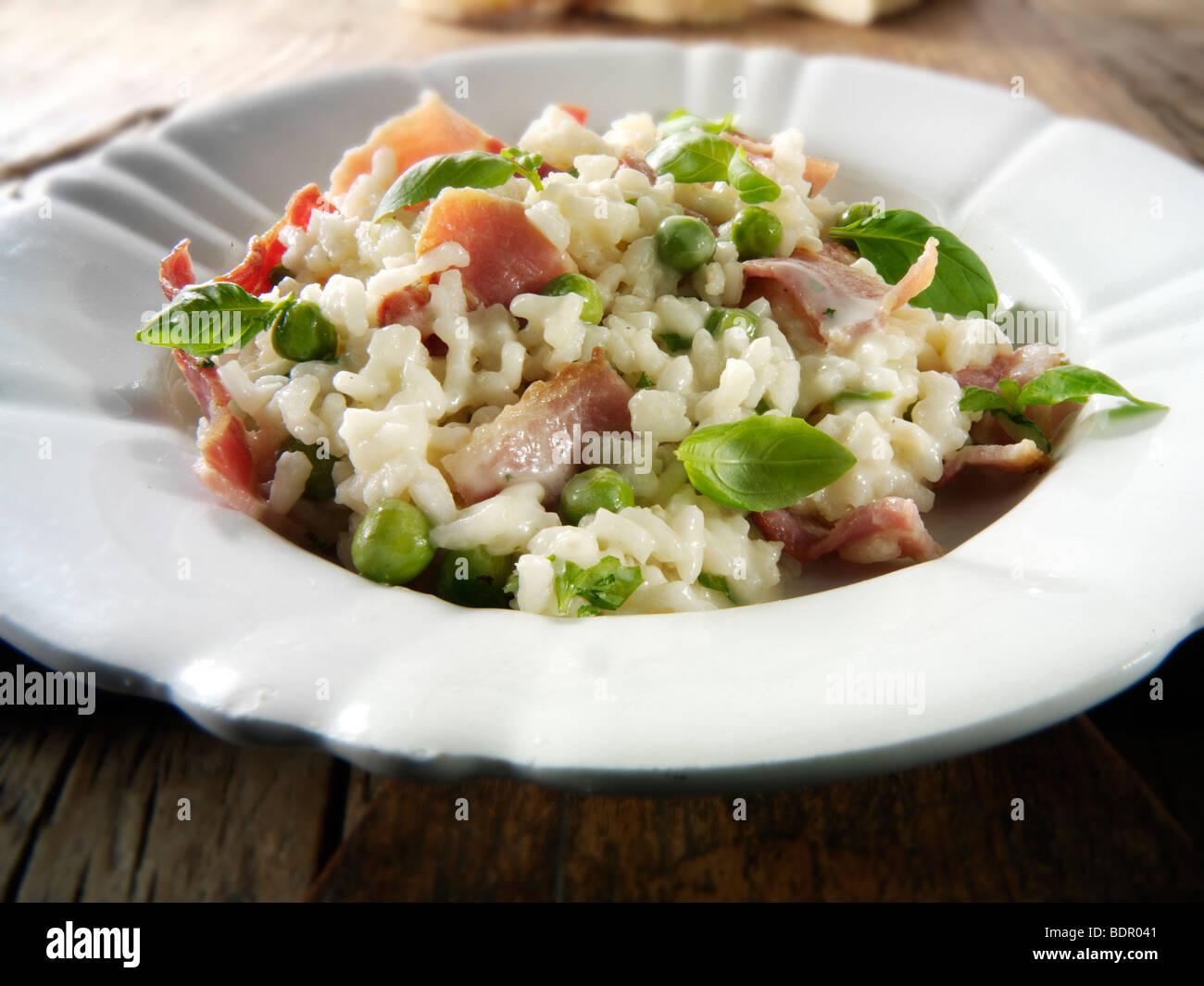 Classic risotto with fresh peas, bacon and mint. Stock Photo