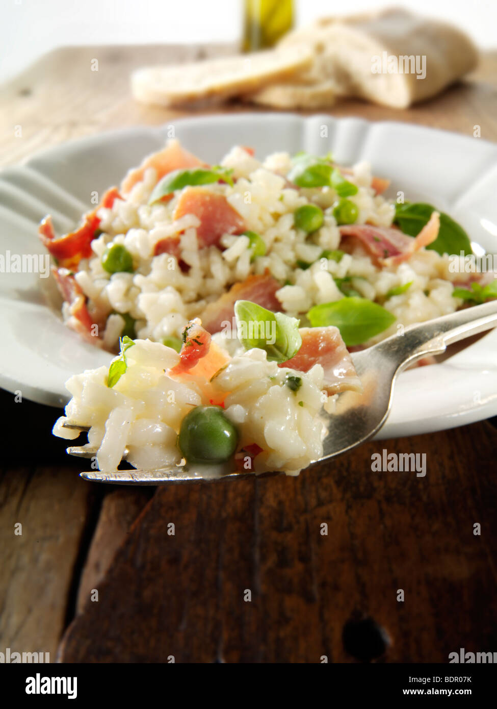 Classic risotto with fresh peas, bacon and mint. Stock Photo