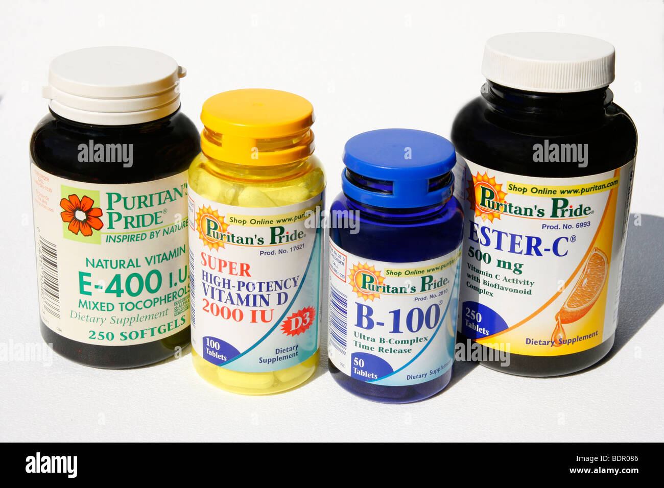 Bottles of vitamin supplements: E, D, B, and C. Stock Photo