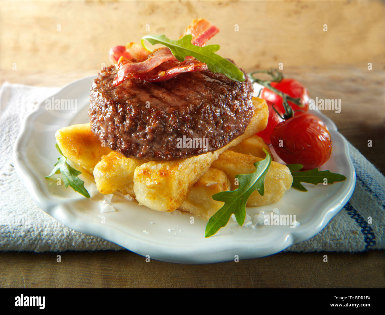 Char grilled beef burger and bacon with chunky chips and salad Stock Photo