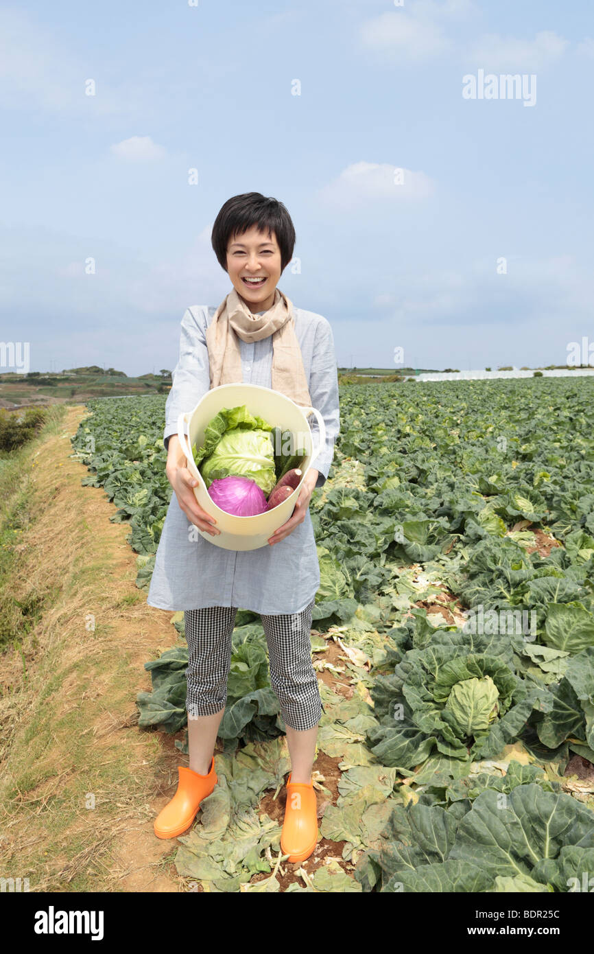 Young woman standing in field Stock Photo - Alamy
