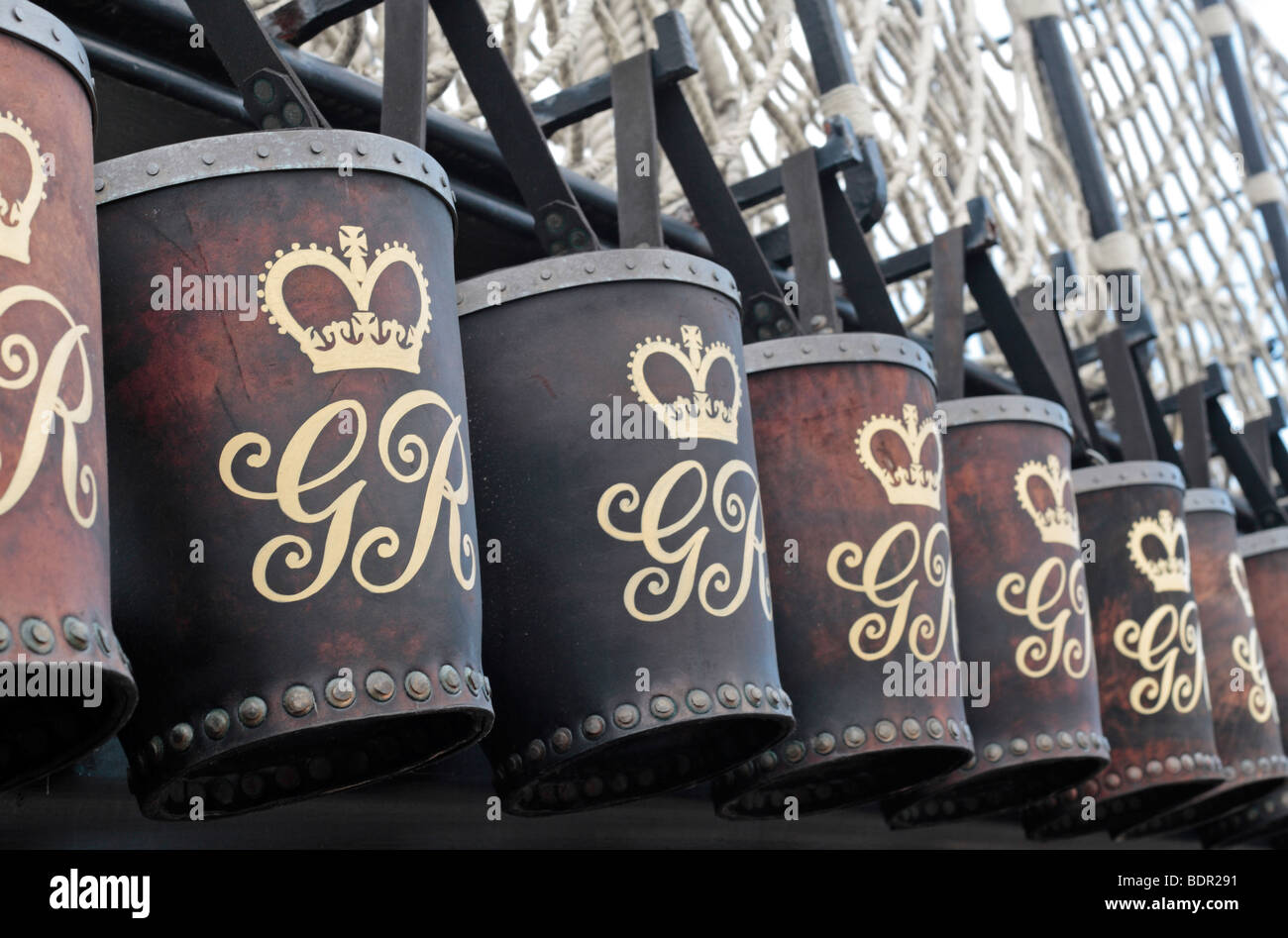 A line of embossed fire buckets hanging along the edge of the poop deck on  board HMS Victory, Portsmouth Historic Dockyard, UK Stock Photo - Alamy