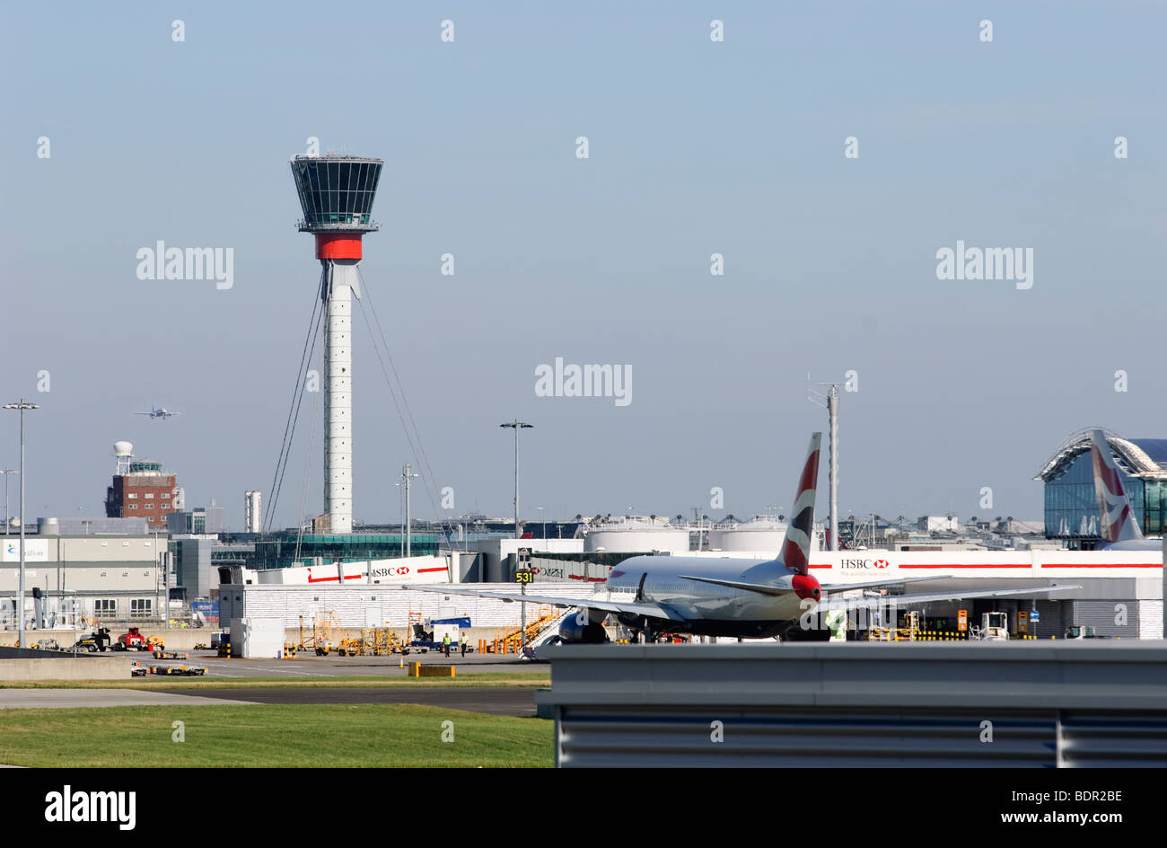 London Heathrow Airport, showing both old and new air traffic control towers, and a parked British Airways Boeing 777. Stock Photo