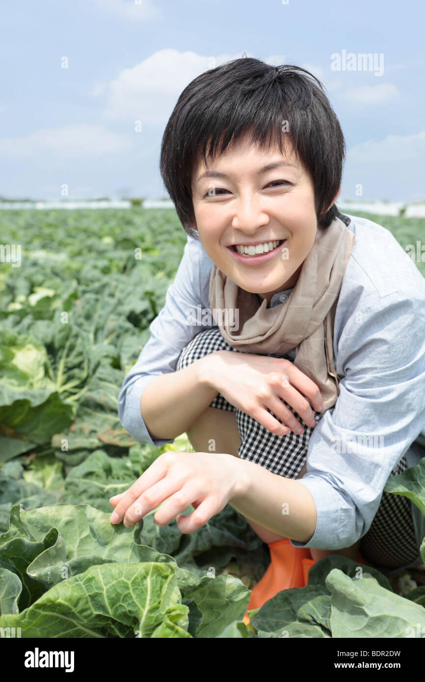 Young woman squatting in cabbage field Stock Photo Alamy