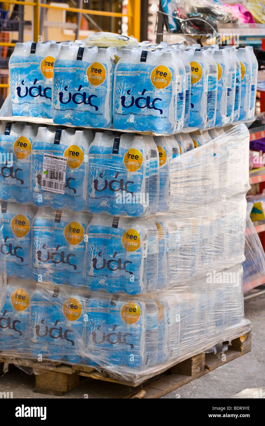 Pallet stack of bottled water outside shop in village of Fiskardo on