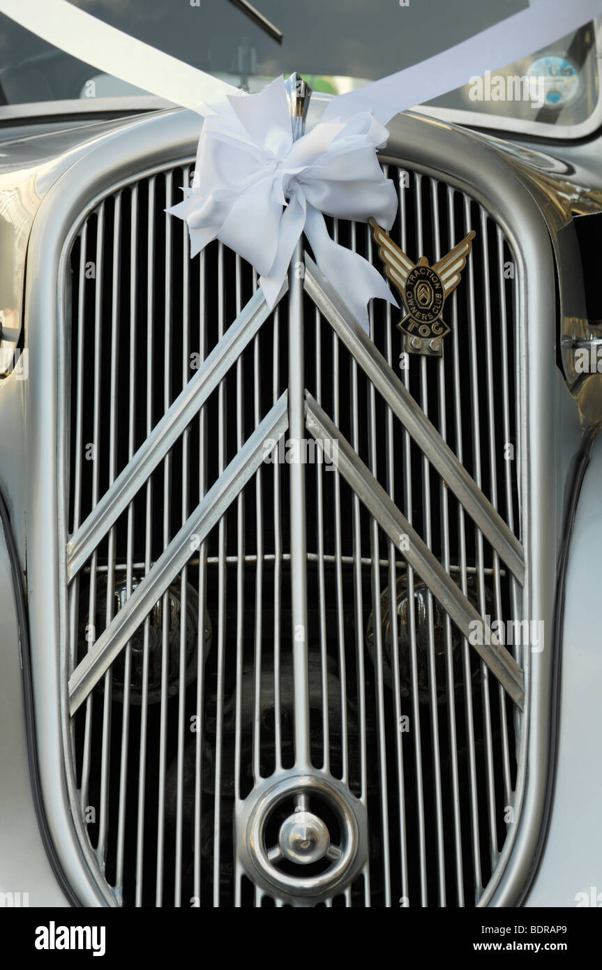 The front of a fully restored silver Citroen Traction Avant Légère being used as a wedding car complete with white ribbon. Stock Photo