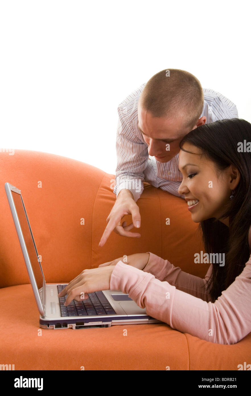 Junger Mann zeigt seiner Freundin, wie ein Laptop funktioniert Stock Photo