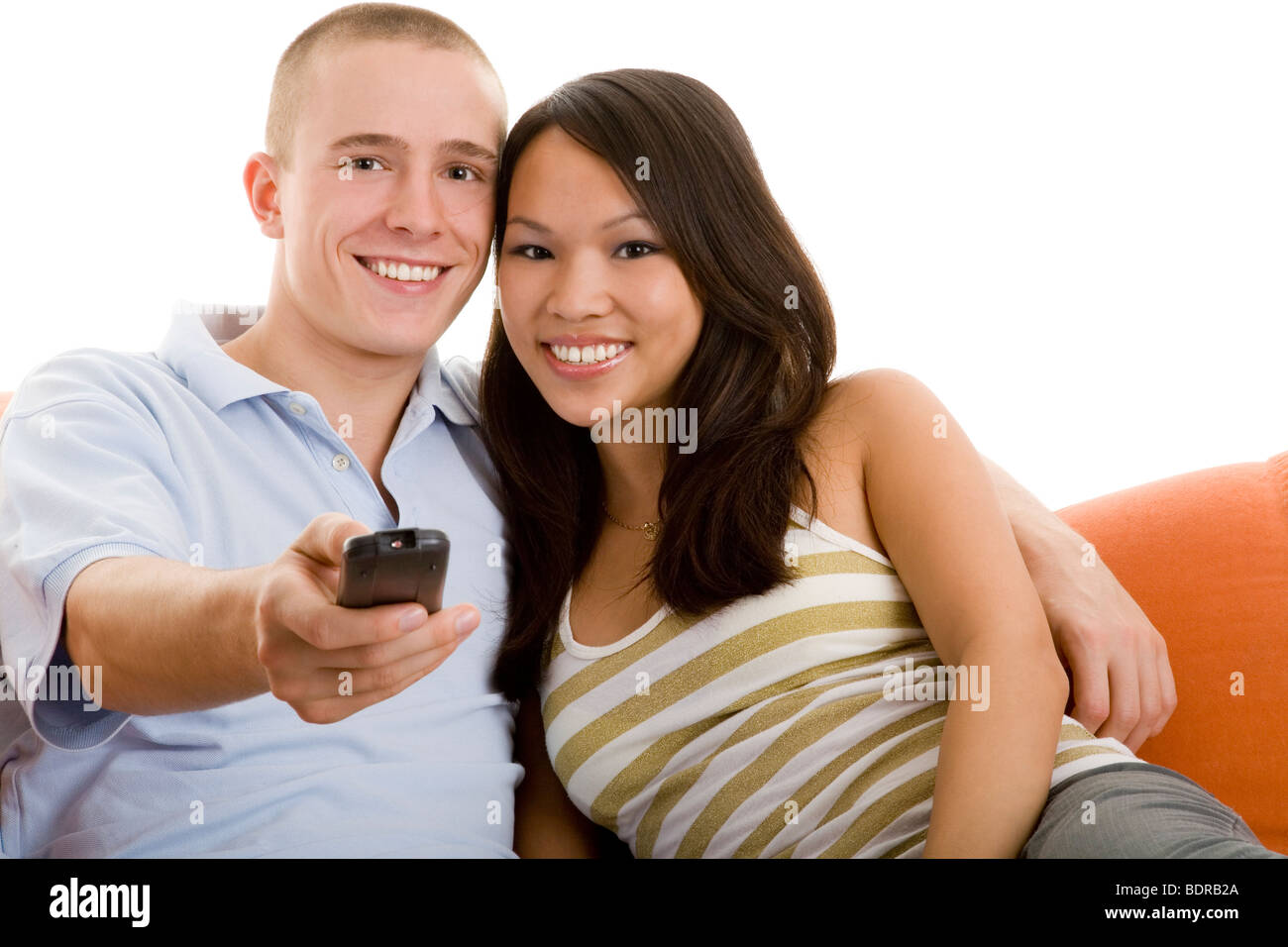 Junes Paar sitzt lachend auf dem Sofa und schaut fern Stock Photo